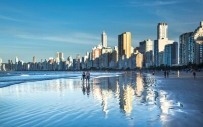 Stunning view of Balneário Camboriú's modern skyline reflecting on the beach at daytime.